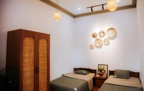 1 dormitorio con 2 camas y platos en la pared en Villa Hồng Phúc, en Ấp Thiện Lập