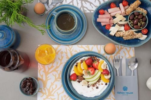 a table with two plates of food and a cup of coffee at Sifnos House - Rooms and SPA in Kamarai