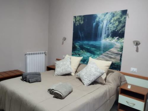 a bedroom with a bed with a painting on the wall at Nexus 2, Recale, Campania in Recale