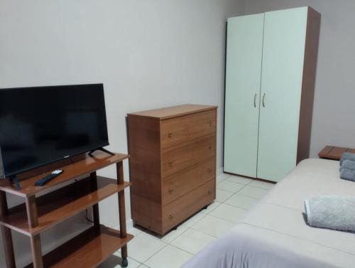 a bedroom with a television and a dresser with a bed at Nexus 2, Recale, Campania in Recale