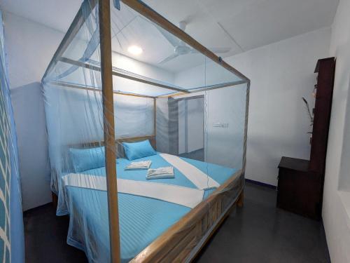 a bed with a glass canopy in a room at Manha Blue Villa Arugambay in Arugam Bay