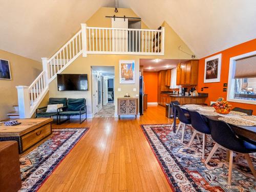 a living room with orange walls and a staircase at Moki Pines Chalet - Stylish Stay Among the Pines in Flagstaff