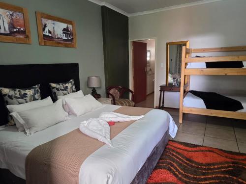 sypialnia z dwoma łóżkami i łóżkiem piętrowym w obiekcie Two Bells Guest House w mieście Bloemfontein