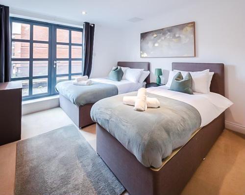 a bedroom with two beds and a large window at Central 2BR flat - free parking - fast Wi-Fi in Bristol