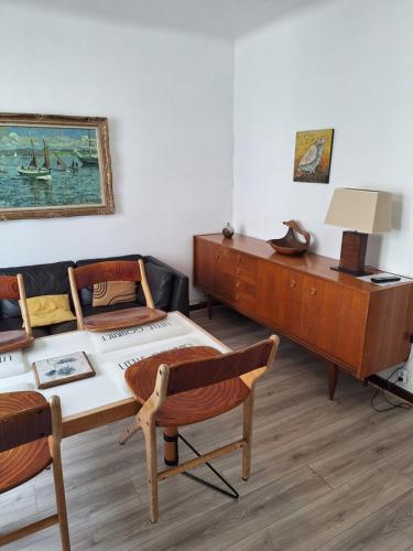 ein Wohnzimmer mit einem Schreibtisch und einem Sofa in der Unterkunft Appartement Argeles sur Mer F3 45m wifi in Argelès-sur-Mer