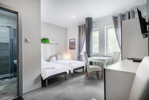 a white room with a bed and a table and chairs at Hostel Gdynia - Pokoje 2-osobowe na wyłączność in Gdynia