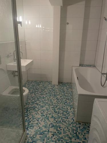 a bathroom with a toilet and a tub and a sink at Your exclusive holiday home in Winterthur