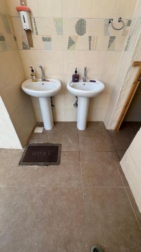 a bathroom with two sinks and a sign that says wrong at SafeZone Guesthouse in Dahab