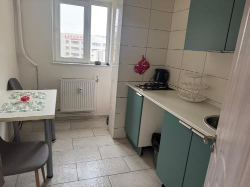 a small kitchen with a sink and a table at Garsoniera centru in Craiova