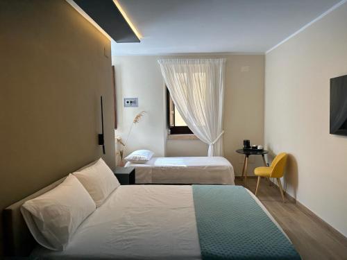 a hotel room with two beds and a window at al Vico Bedrooms in Crotone