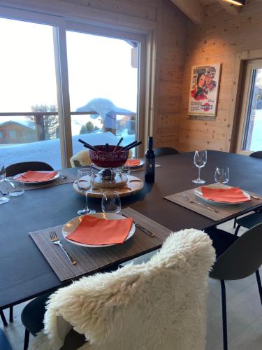 a wooden table with glasses and a bowl on it at Ski in out Swiss Alps Chalet Charelle by Jolidi in Nendaz