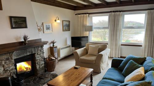 ein Wohnzimmer mit Couch und Kamin in der Unterkunft Craobh Haven Cottages in Craobh Haven