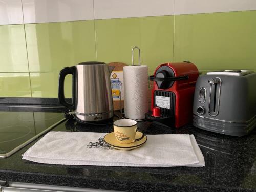 eine Kaffeemaschine und eine Kaffeetasse auf der Theke in der Unterkunft Santo Amaro Beach Family Stays in Oeiras