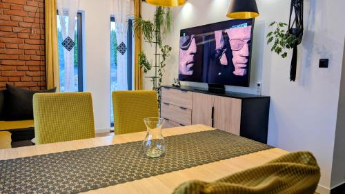 a dining room with a table and a television at Zajazd u George'a in Ziębice