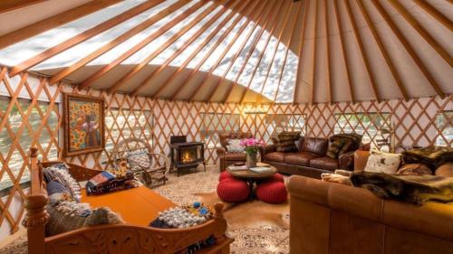 a yurt with a couch and a table in a room at Cozy Romantic Yurt Rental in Woodlands near California Beach Town of Cayucos in Cayucos