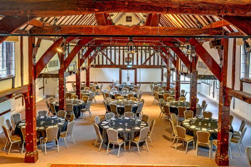 a banquet hall with tables and chairs in a building at Sunday Box Hill Burford Bridge Hotel in Dorking