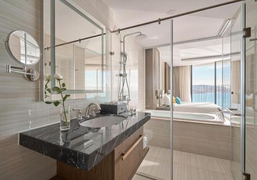a bathroom with a sink and a bath tub at Panorama Sky Beach Recidences in Nha Trang