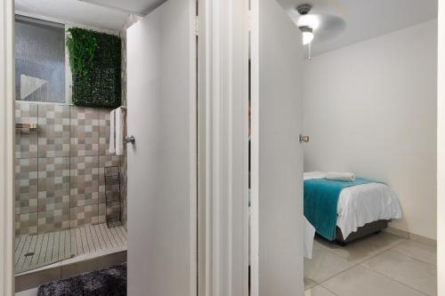 Un baño con ducha y una cama en una habitación. en Seaside Sunsets, en Strand