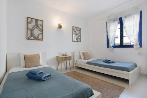 twee bedden in een kamer met witte muren en ramen bij Los Morros in Punta de Mujeres
