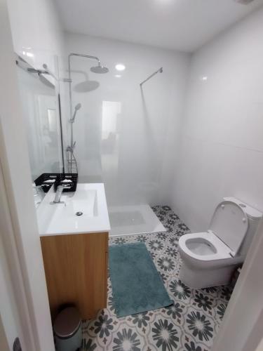 a white bathroom with a toilet and a sink at Gite espumante in Mamarrosa