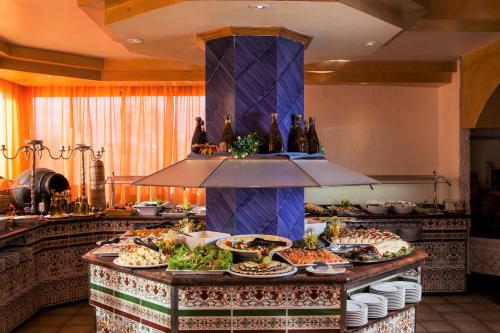 a buffet with many plates of food on a table at Park Club Europe - All Inclusive Resort in Playa de las Americas
