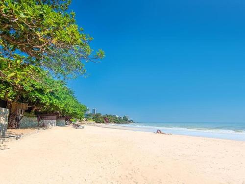 a beach with people laying on the sand at 3BR Pool Villa Beach Access Patumnak Hill in Pattaya South
