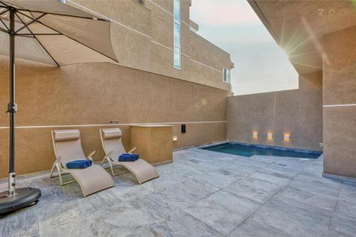 a room with two chairs and a swimming pool at The Pender LUX HUB - 4BR villas with Pool, WIFI & AC by 360 Estates in St. Julianʼs