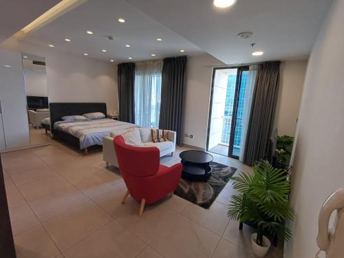 a bedroom with a bed and a red chair at Studio at Damak Jordan in Amman