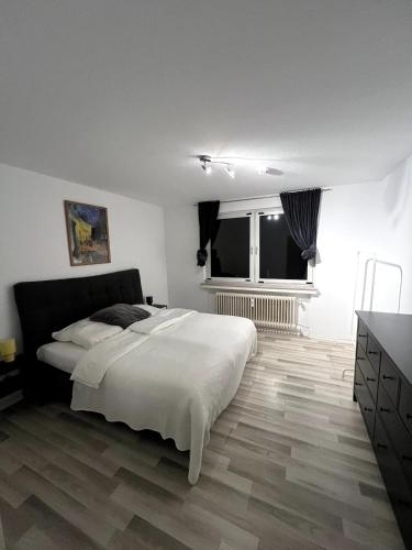 a bedroom with a large white bed and a window at Somewhere2Stay Apartment in Oberhausen City in Oberhausen