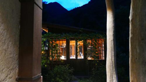 een huis met een poort met bergen op de achtergrond bij Jinglu Lanshan Inn in Fuchunjiang