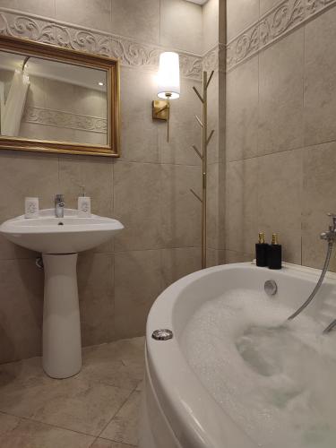 a bathroom with a bath tub and a sink at Mountain View Apartment in Florina