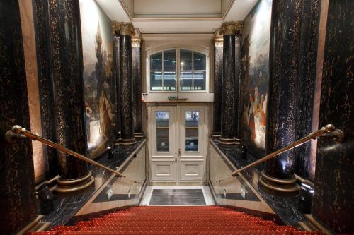a hallway with a white door and a red carpet at Acom Hotel Berlin Kurfürstendamm in Berlin