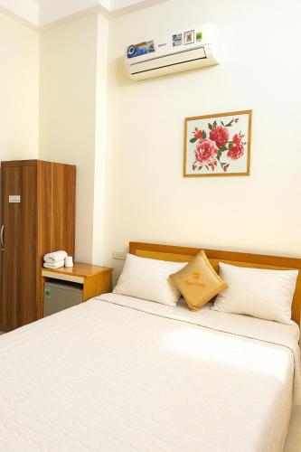 a bedroom with a white bed and a wooden cabinet at Tấn Đạt Hotel Quy Nhơn in Quy Nhon