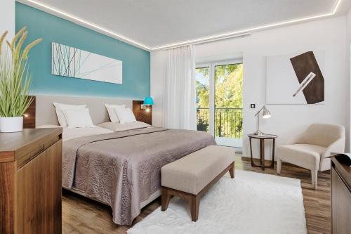 沃尔特湖畔韦尔登Boutiquehotel Wörthersee - Serviced Apartments的一间卧室，里面有一张床、一把椅子和一扇窗户