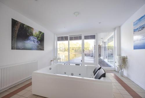 uma grande casa de banho branca com uma grande banheira em Fletcher Hotel - Resort Spaarnwoude em Velsen-Zuid