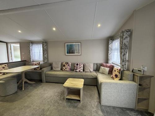 a living room with a couch and a table at 64, Belle Aire Caravan Park, Sleeps 6, Bed Linen and Towels Included, Free WiFi, Pets Welcome with onsite clubhouse in Great Yarmouth