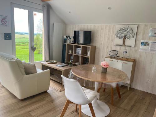 a living room with a table and a chair at Gîte avec vue imprenable sur la campagne in Courgains