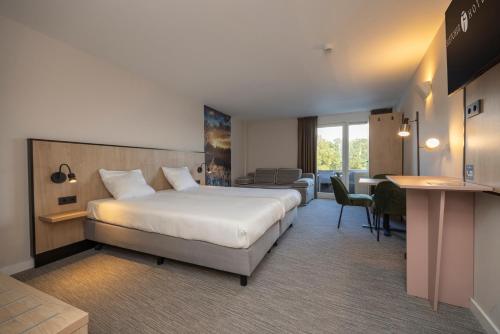 um quarto de hotel com uma cama grande e uma escrivaninha em Fletcher Hotel - Resort Spaarnwoude em Velsen-Zuid