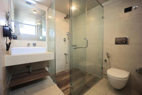 a bathroom with a shower and a sink and a toilet at Club Mahindra Pavagadh in Rawālia