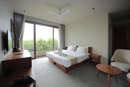 a bedroom with a bed and a large window at Club Mahindra Pavagadh in Rawālia