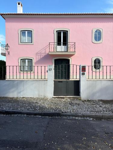 a pink house with a door on a street at Casa de S Bento in Santarém