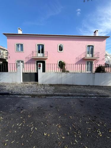 a pink house with a fence in front of it at Casa de S Bento in Santarém