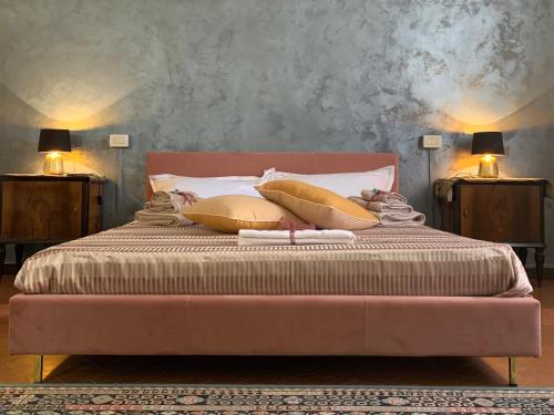 een slaapkamer met een bed met gouden kussens en twee lampen bij La casa di Hermes in Imola