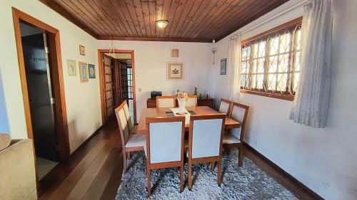 une salle à manger avec une table et des chaises et une fenêtre dans l'établissement Casa Serra Azul, à Campos do Jordão