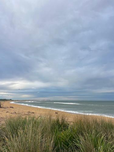 a sandy beach with the ocean in the background at River meets the Sea in Stockton