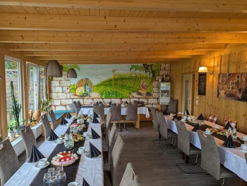 a dining room with tables and chairs and a mural at Pension Sommerfrische in Nebra