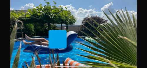 een persoon op een blauwe stoel in een zwembad bij Villa Kaja mit Pool, Kamin und traumhaftem Blick auf den Möhnesee in Delecke