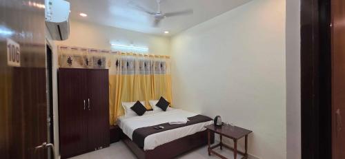 a small bedroom with a bed and a television at Hotel O Banaras Guest House in Banāras Cantonment