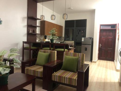 a living room with two chairs and a table at Neema maison de Glamour in Entebbe