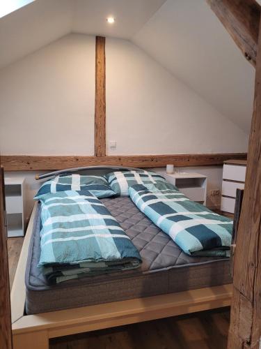a bed with blue and white pillows on it at Ferienwohnung Lindenblüte in Eggenthal